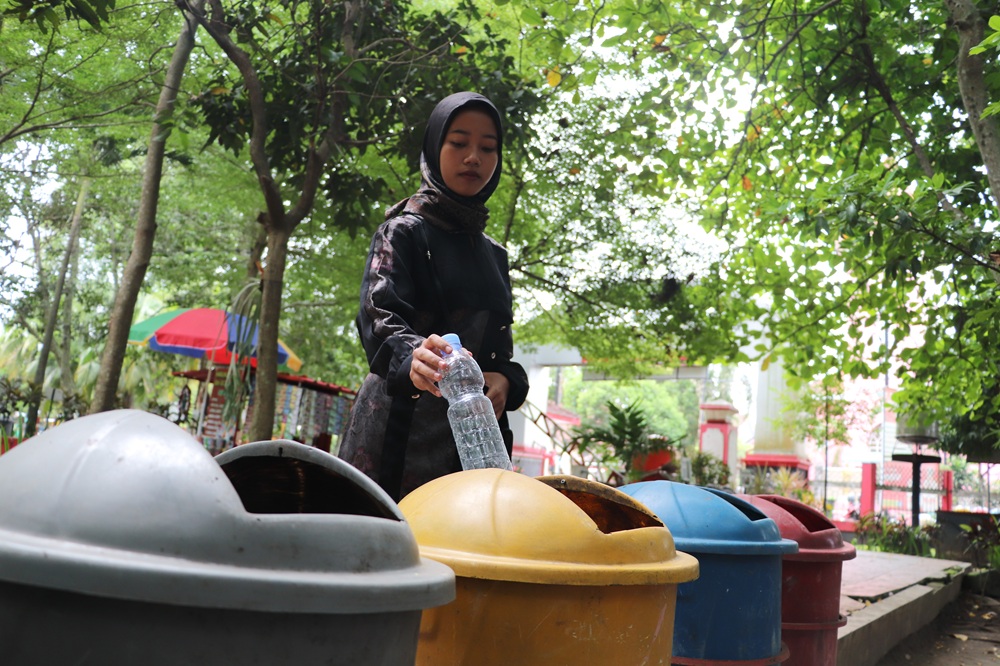 BERUSAHA BERSIH: Salah satu masyarakat di Blitar membuang sampah di RTH untuk melestarikan lingkungan.