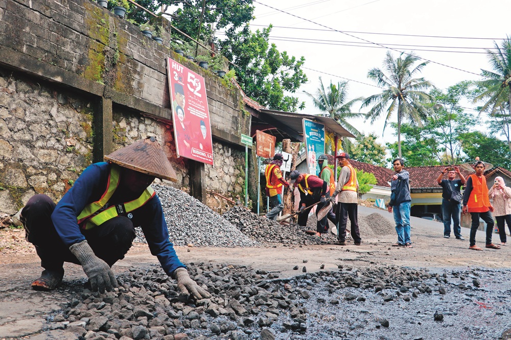 TAMBAL SULAM: Tim URC Dinas PUPR Kabupaten Blitar melakukan perbaikan jalan di Kecamatan Bakung beberapa waktu lalu.