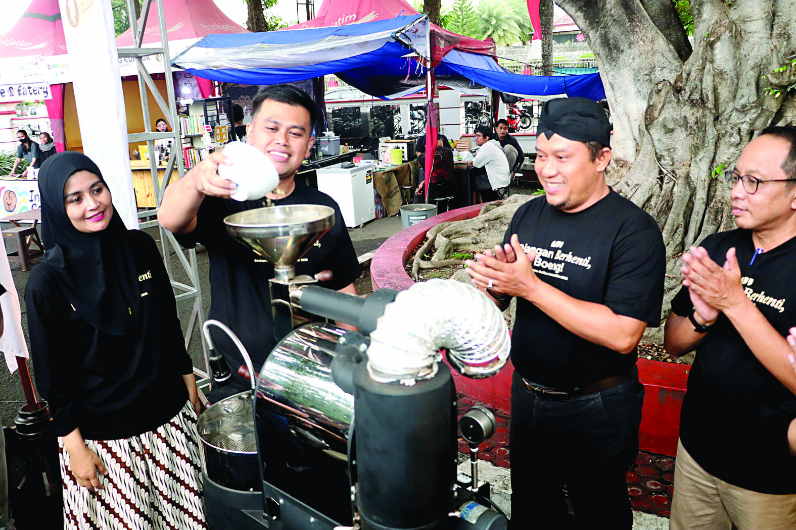 INDUSTRI KREATIF: Wali Kota Blitar, Mas Ibin, menuangkan green beans ke mesin penggiling kopi saat pembukaan SCF 2025 di halaman Kantor Wali Kota, kemarin (13/6/2025).