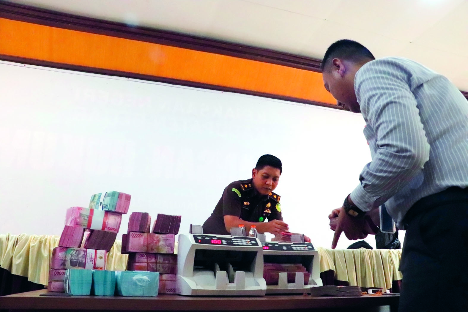 RUGIKAN NEGARA: Tim Kejari Kabupaten Blitar menghitung uang hasil korupsi tersangka MM yang dikembalikan, Senin (23/6/2025).