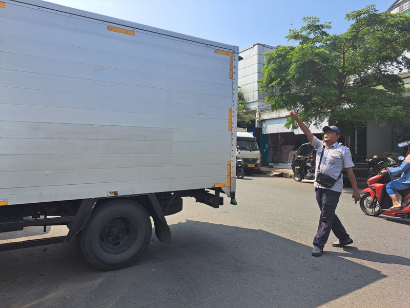 TANGGUNG JAWAB: Petugas parkir resmi membantu masyarakat untuk memarkirkan kendaraan roda empat di Pasar Wlingi.