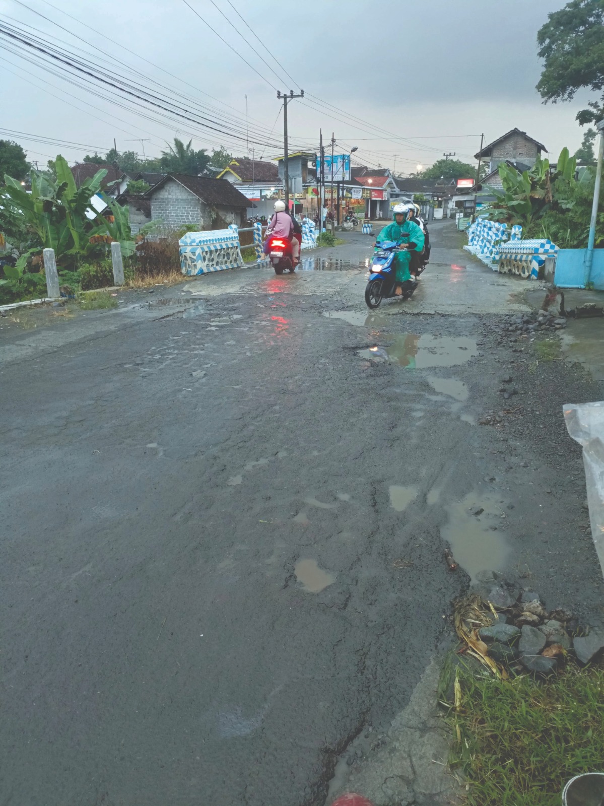 HARUS HATI-HATI: Masyarakat saat melintas di Jembatan Kali Mlalo, Desa Sukosewu, Kecamatan Gandusari, pada Minggu (29/6).