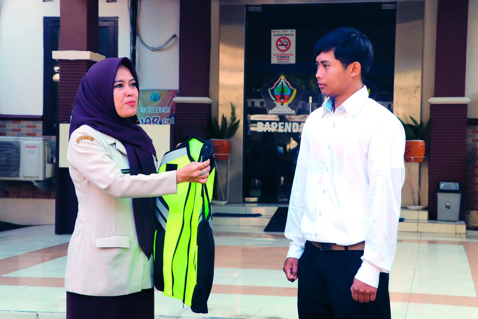 INOVASI: Kepala Bapenda Kabupaten Blitar Asmaning Ayu memasangkan rompi kepada petugas pos pengawas pajak MBLB secara simbolis, saat apel pelepasan, Selasa (1/7/2025).