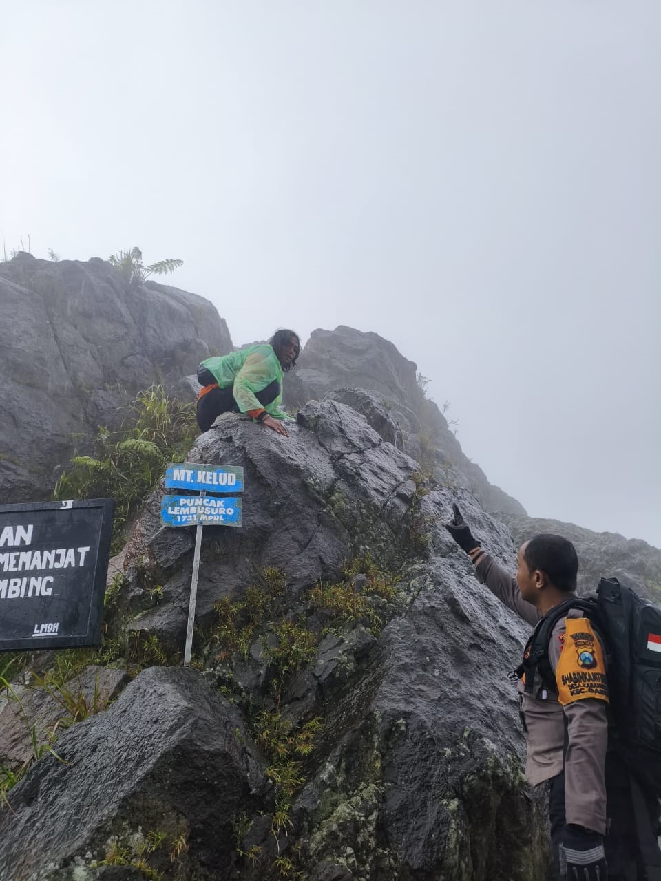 HARUS HATI-HATI: Aris Bores (atas) bersama Bhabinkamtibmas Desa Karangrejo saat pemasangan papan imbauan agar tidak memanjat salah satu puncak di Gunung Kelud.