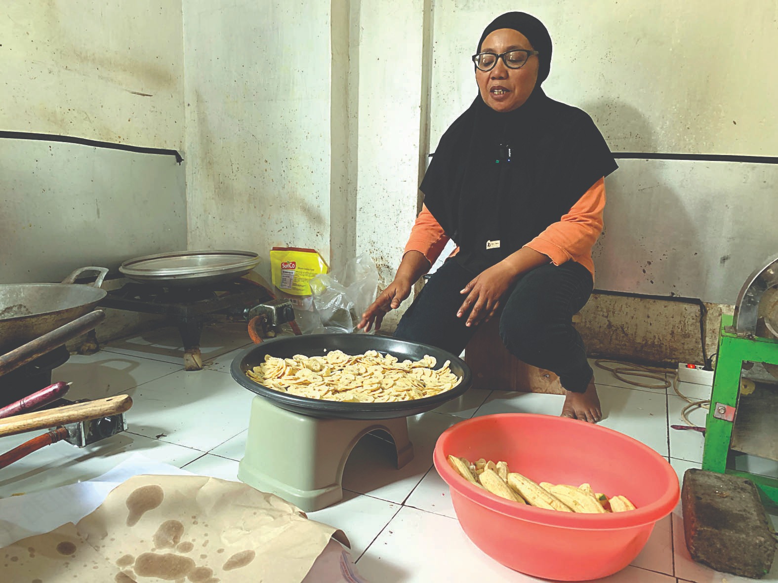 SEMANGAT: Reni Setyawarni bersiap untuk menggoreng pisang yang telah diiris tipis-tipis ke minyak panas, Rabu (9/7/2025).