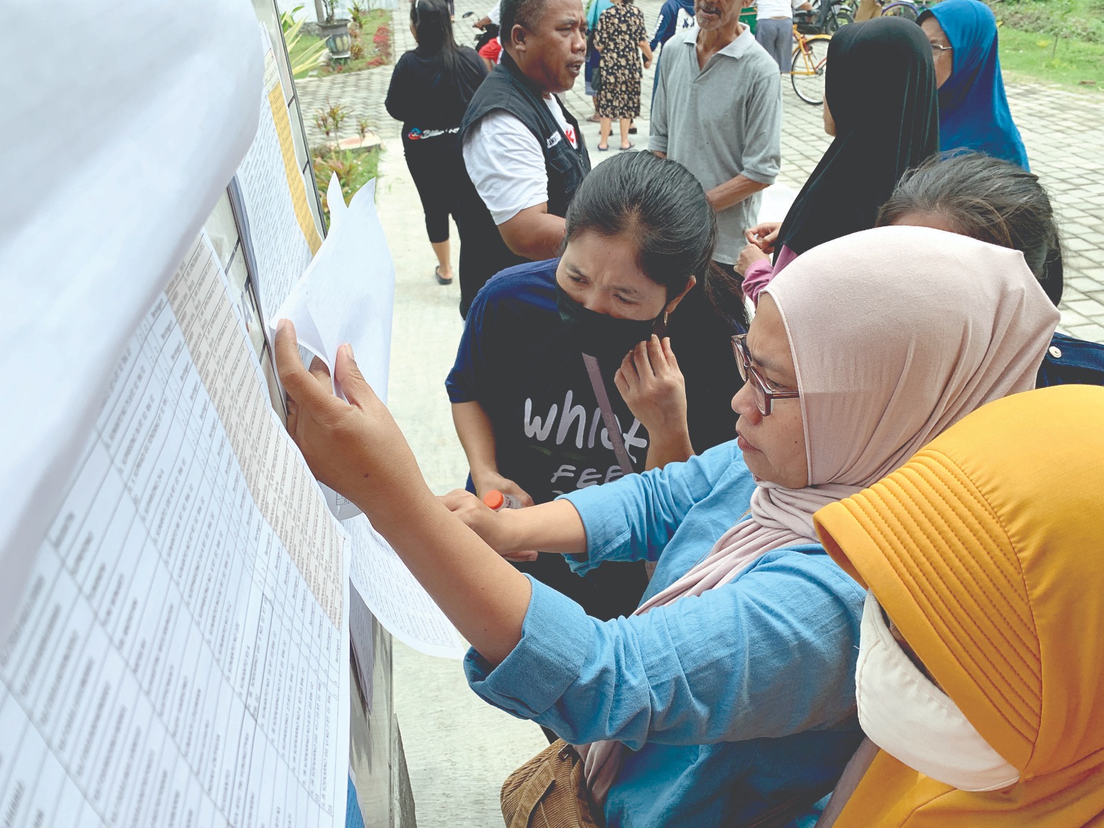 TELITI: Warga Kelurahan Bendogerit penerima bantuan rastrada melihat daftar pengambilan rastrada di toko mitra beberapa waktu lalu.