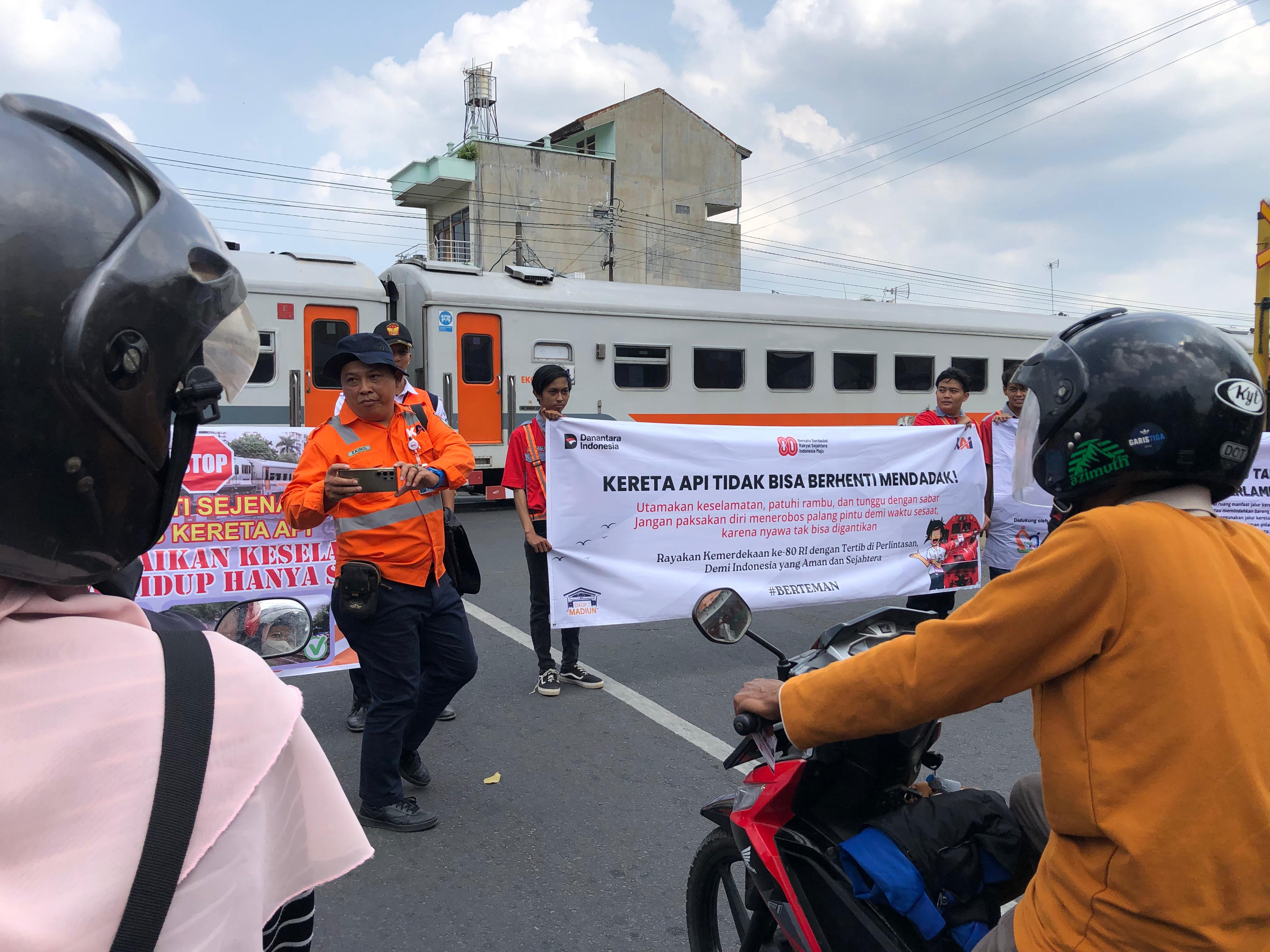 CEGAH KECELAKAAN: Petugas KAI dan komunitas railfans kampanye keselamatan di palang pintu perlintasan di Jalan Anggrek kepada pengguna jalan, Rabu (13/8/2025).
