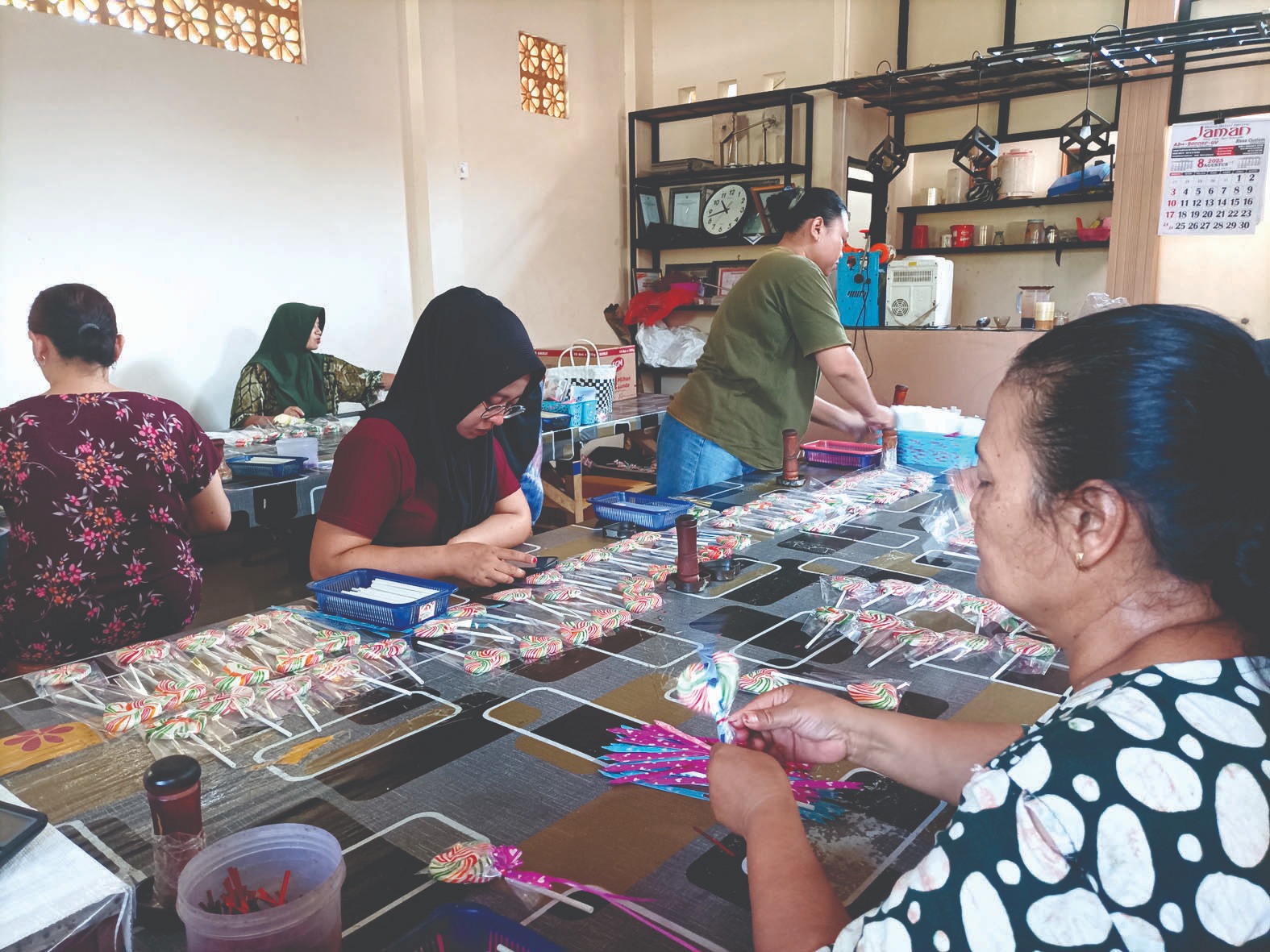 KAWULA: Ibu-ibu pekerja sibuk mengemas permen lolipop sebelum dijual ke pasaran, Selasa (2/9/2025).