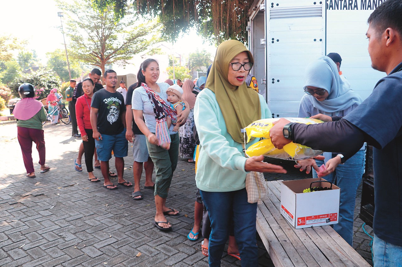 HARUS TERJAGA: Warga membeli beras SPHP saat kegiatan operasi pangan murah di Pasar Kanigoro.