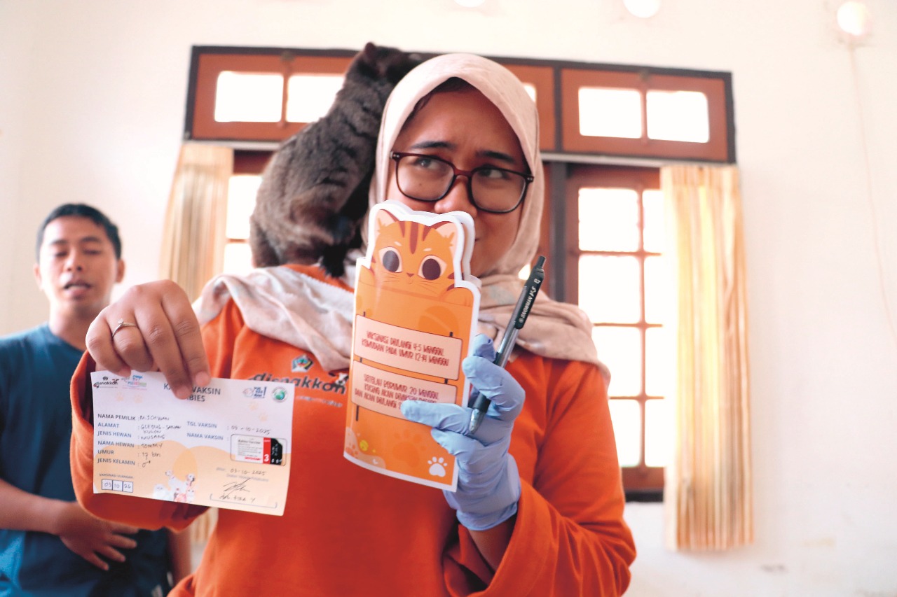 EDUKASI: Dokter hewan Disnakkan Kabupaten Blitar sedang menunjukkan brosur yang berisi petunjuk vaksinasi rabies selanjutnya.