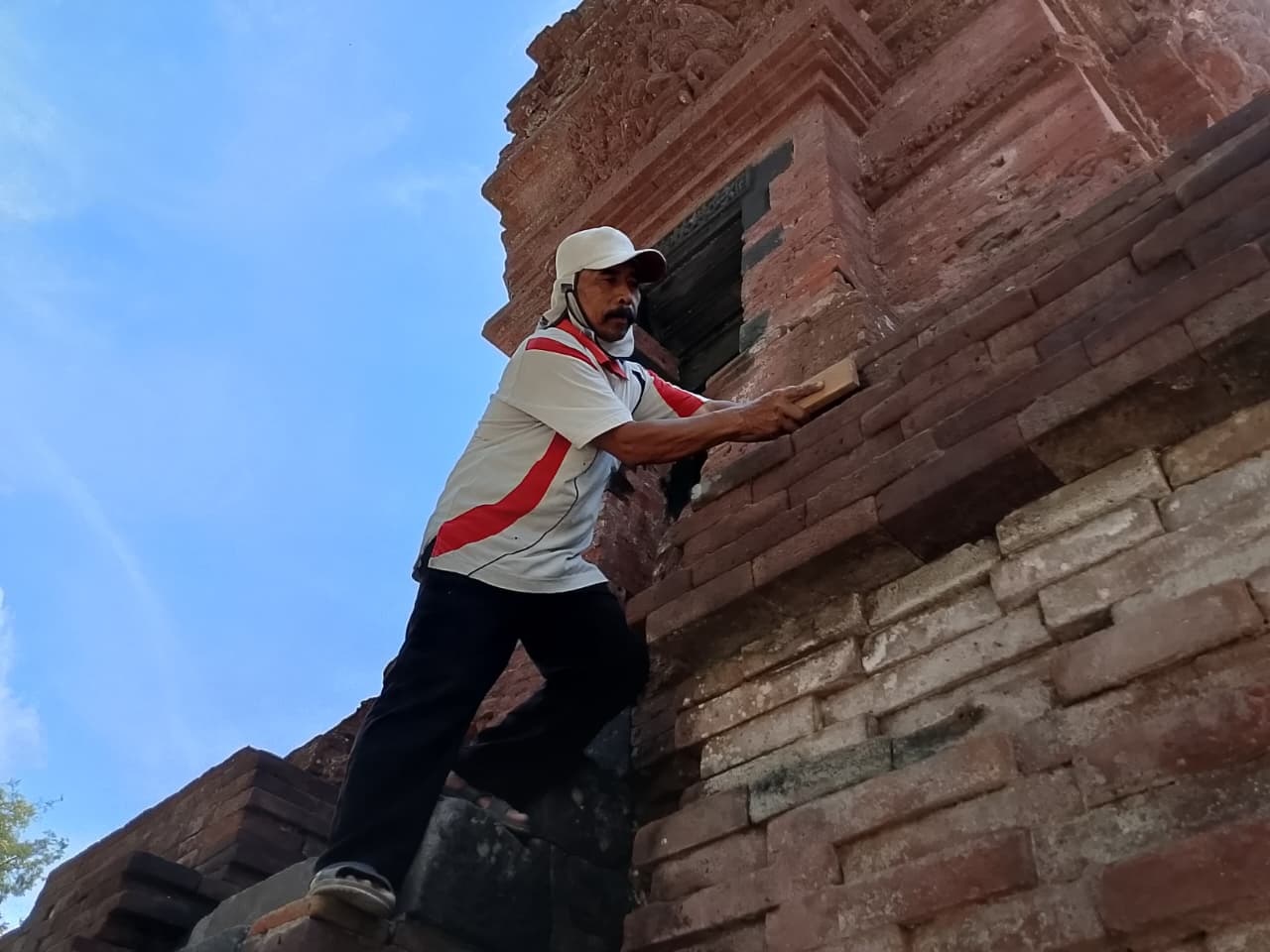 &lrm;DIRAWAT: Juru pelihara Candi Kalicilik tengah membersihkan struktur bangunan candi agar tetap terlihat bersih.
