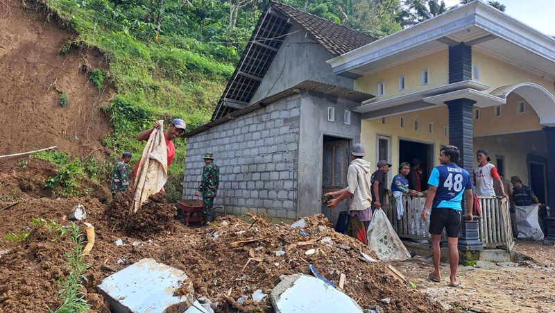 KERJA BAKTI: Warga bersama petugas gabungan melakukan pembersihan material longsor di rumah Mukri, warga Desa Tulungrejo, Gandusari, Kabupaten Blitar, Kamis *23/10/2025).