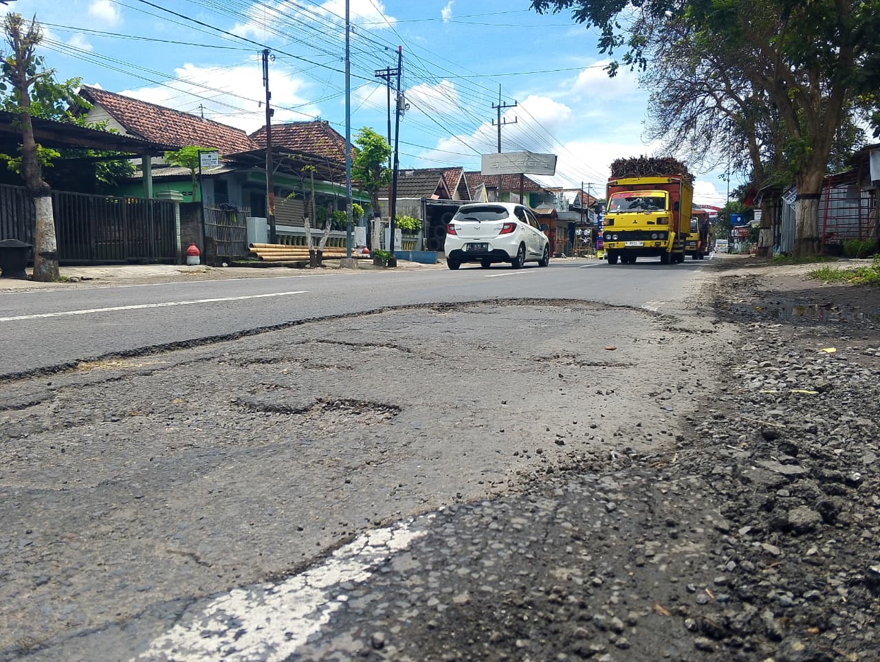 DISAMBUT: Jalan berlubang jadi pemandangan pertama saat pengendara memasuki gapura pintu masuk Kabupaten Blitar bagian barat.