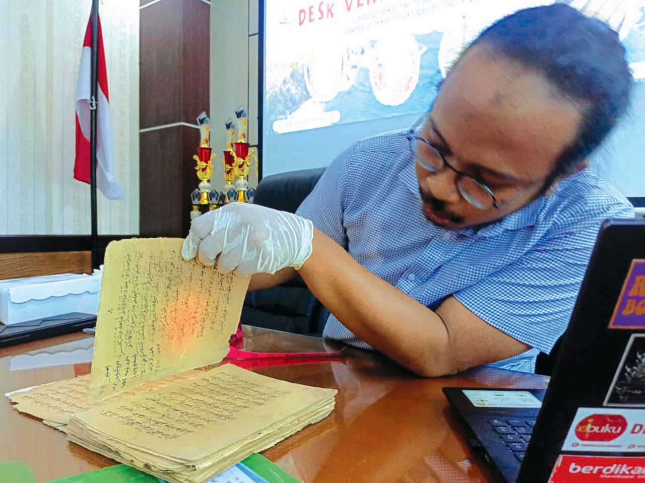 TELITI: Filolog Universitas Airlangga, Dr Abimardha Kurniawan saat memverifikasi naskah kuno di Dispusip Kabupaten Blitar beberapa waktu lalu.