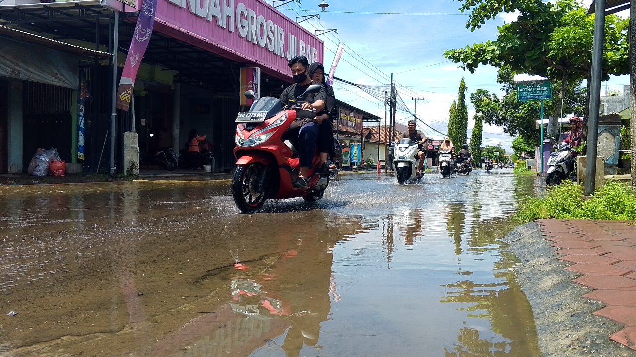 &lrm;MENGGENANG: Kondisi ruas jalan di kawasan Pasar Gambar, Kecamatan Wonodadi, tampak tertutup air akibat guyuran hujan deras.