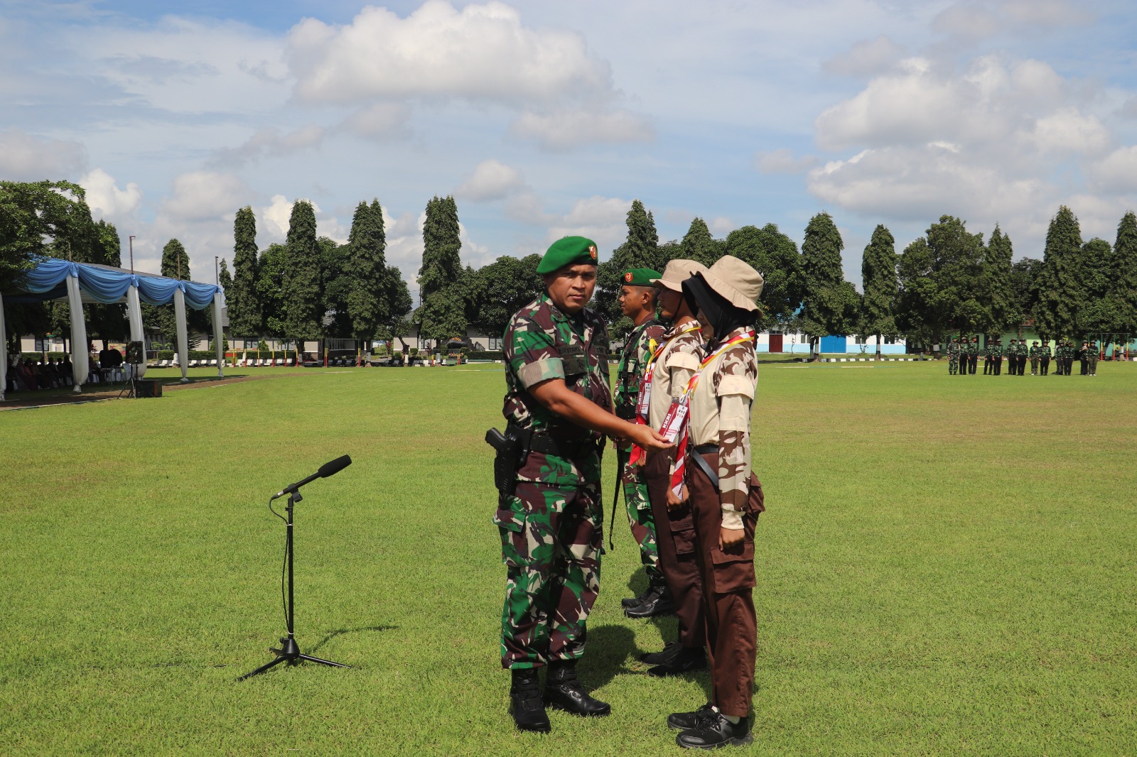 SEMANGAT: Komandan Korem 081/DSJ Kolonel Arm Untoro Hariyanto mengalungkan tanda nama peserta Persami KKRI di Yonif 511/DY Blitar, Sabtu (6/12/2025).