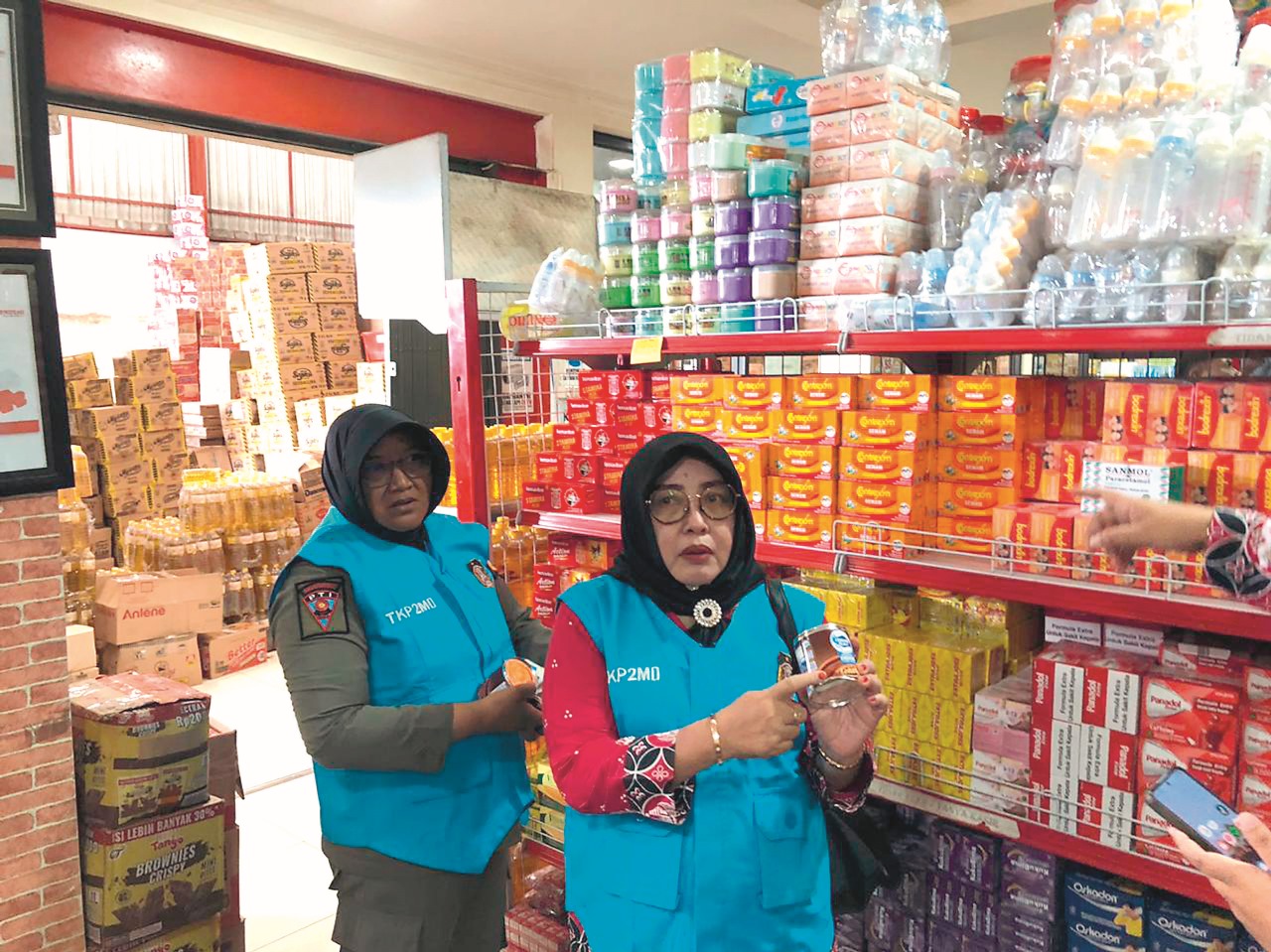 BERISIKO: Petugas TKP2MO Kota Blitar menunjukkan kaleng susu kental manis yang penyok dan minta pemilik toko untuk menyingkirkan dari etalase, kemarin (11/12).