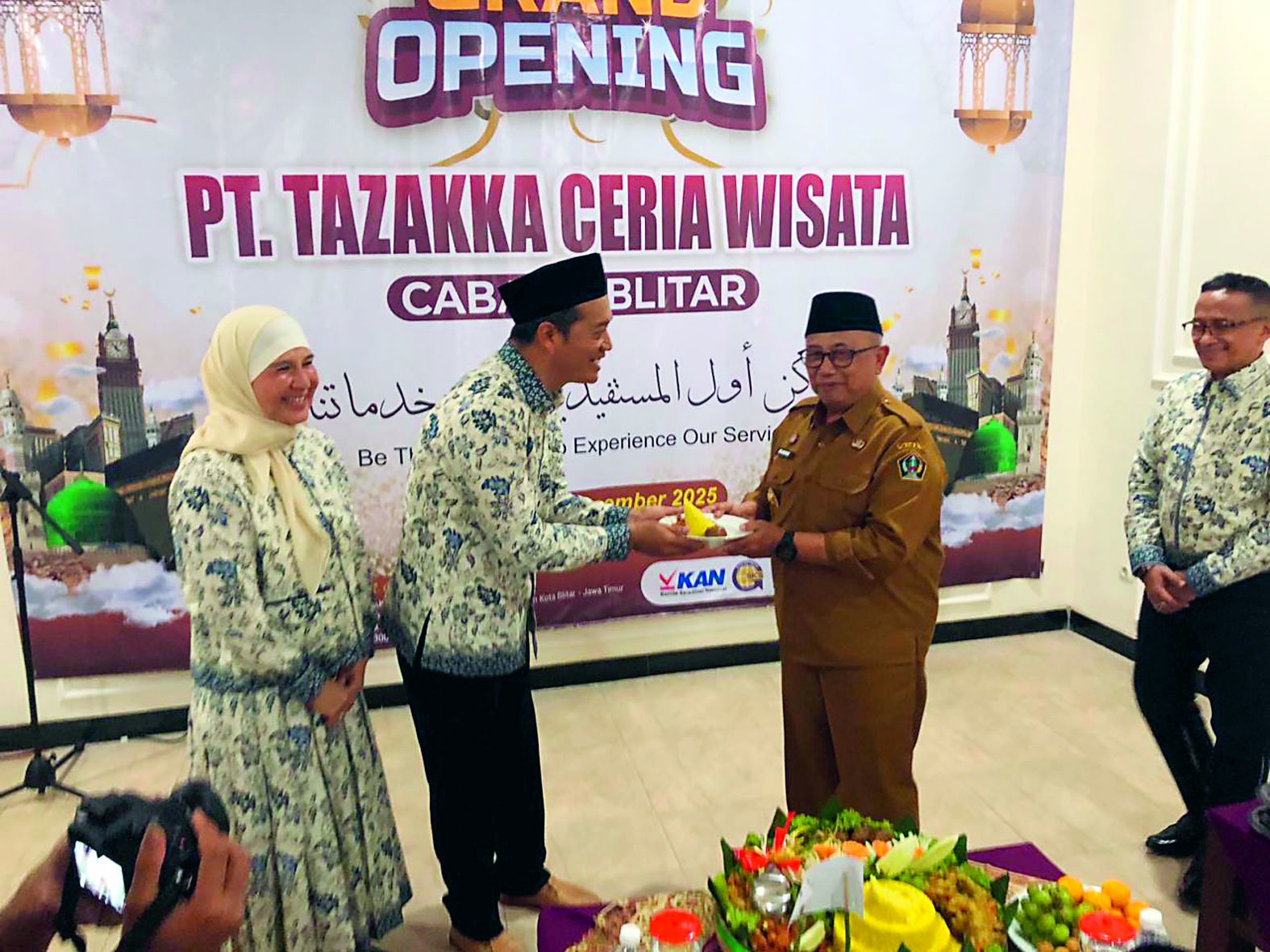 LAYANAN MAKSIMAL: Bupati Blitar Rijanto menyerahkan potongan tumpeng kepada Pimpinan PT Tazakka Ceria Wisata Cabang Blitar, Lukito, Selasa (16/12/2025).