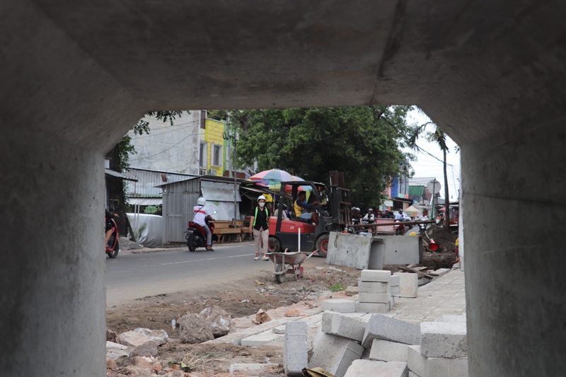 TARGET TUNTAS: Pekerja terus mengebut pekerjaan pavingisasi untuk lahan parkir Pasar Loak di timur Pasar Templek, Kamis (18/12/2025).