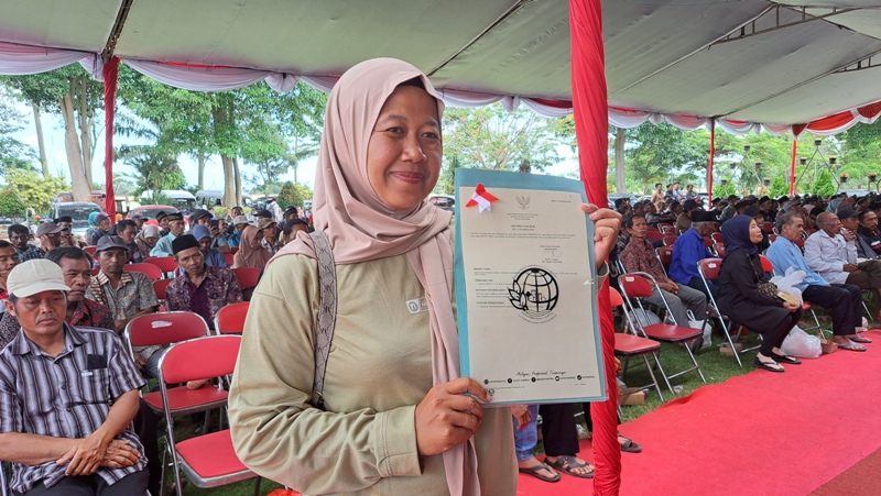 BERSYUKUR: Diah Hartatik menunjukkan SHM yang diperoleh dari ATR/BPN, usai tiga kali ini mengurus sertifikat PPTPKH.