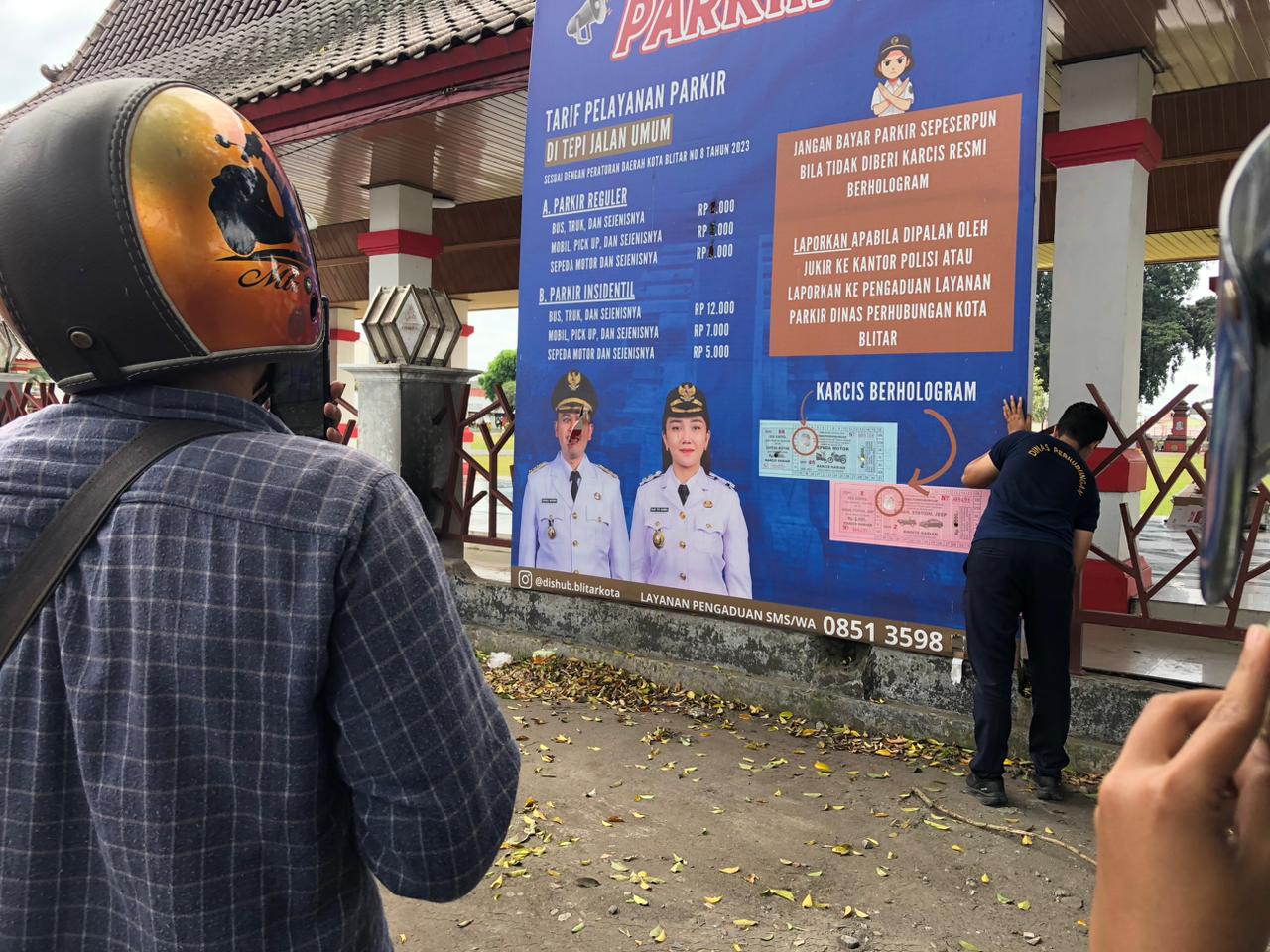 MERESAHKAN: Petugas dishub harus melepas banner yang dirusak di area Alun-alun Kota Blitar, kemarin (8/1).
