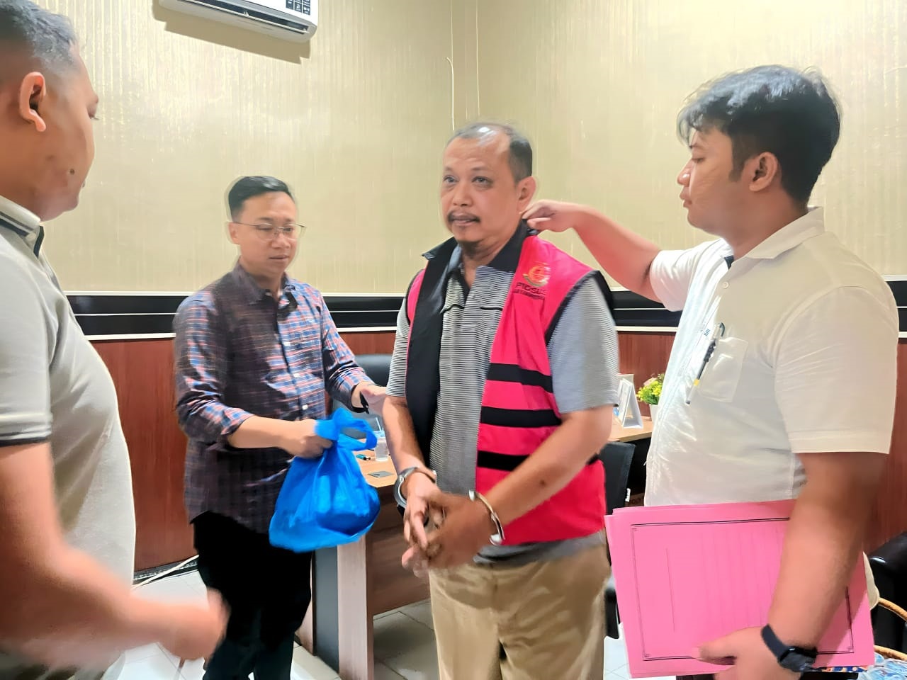 TAK MELAWAN: Salah satu tersangka korupsi Dam Kalibentak Sekretaris Dinas PUPR Kabupaten Blitar, Heri Santoso mengenakan rompi merah muda.