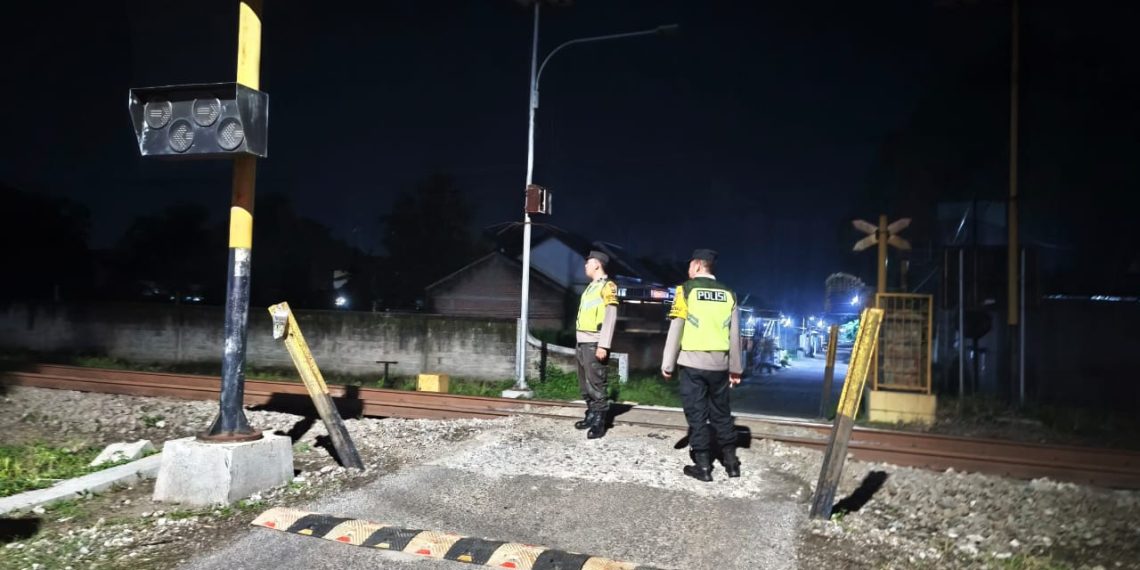 &lrm;PANTAU LOKASI: Personel Polsek Sanankulon saat berpatroli di perlintasan sebidang tanpa palang pintu.