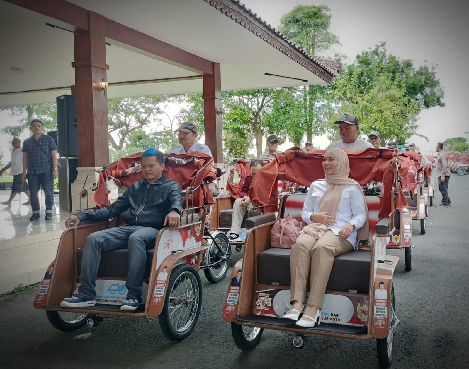 Tukang becak yang mendapatkan becak listrik dari Presiden Prabwo membonceng, Wakil Bupati Blitar BekyHedihansah, dan Wakil Ketua DPC Gerindra, Ratna Dewi Nirwanasari, Sabtu (7/3).