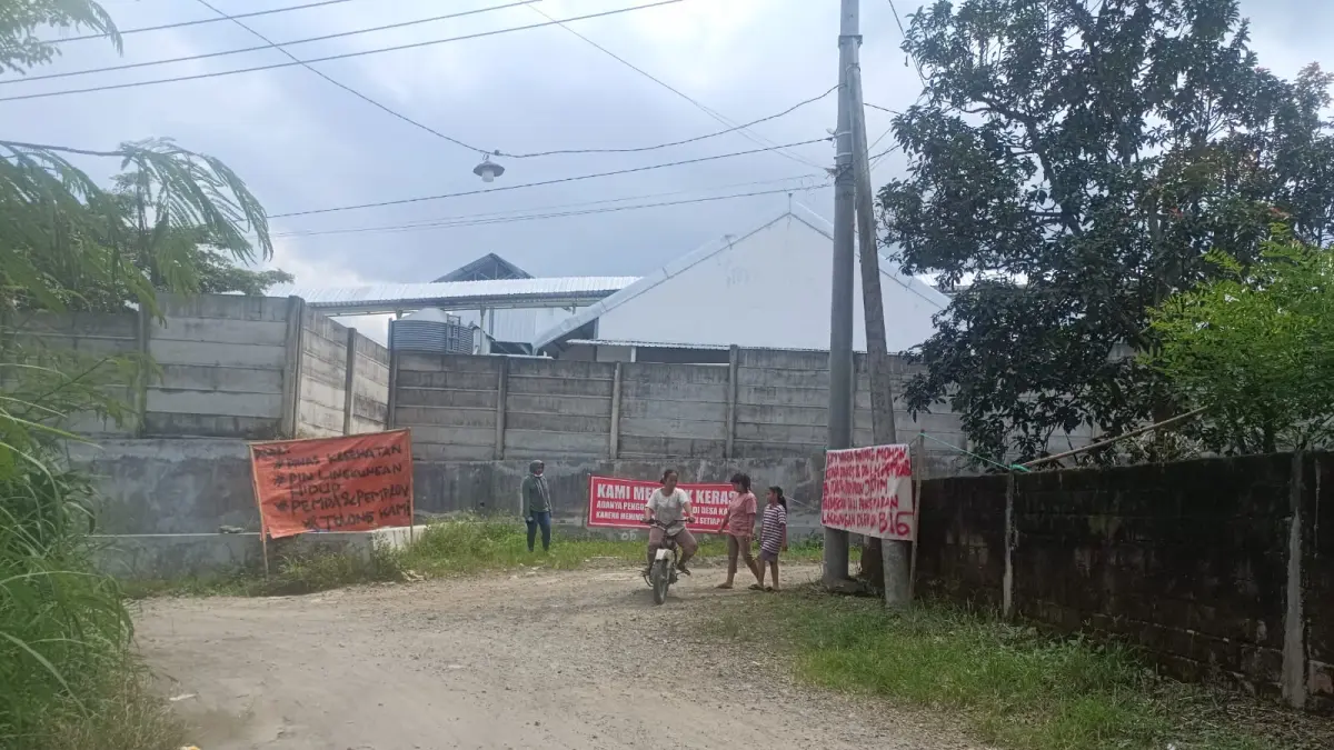 Warga Dusun Bintang, Desa Ngaringan, Kecamatan Gandusari, Kabupaten Blitar memasang banner protes di dekat pengolahan limbah kotoran ayam petelur, Senin (20/4). 