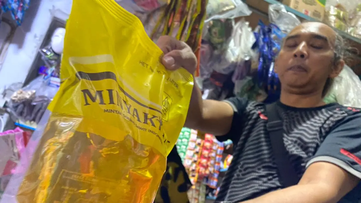 STOK MENIPIS: Seorang pedagang di Pasar Pon mengambil stok MinyaKita kemasan pouch 1 liter, kemarin (23/4). Tingginya minat beli membuat ketersediaan minyak ini cepat menipis sebelum jadwal pengiriman mingguan tiba.