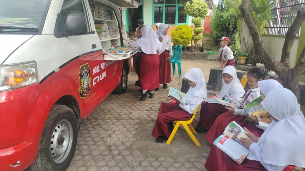 TINGKATKAN LITERASI: Sejumlah siswa menikmati layanan bacaan lewat layanan perpustakaan keliling. 
