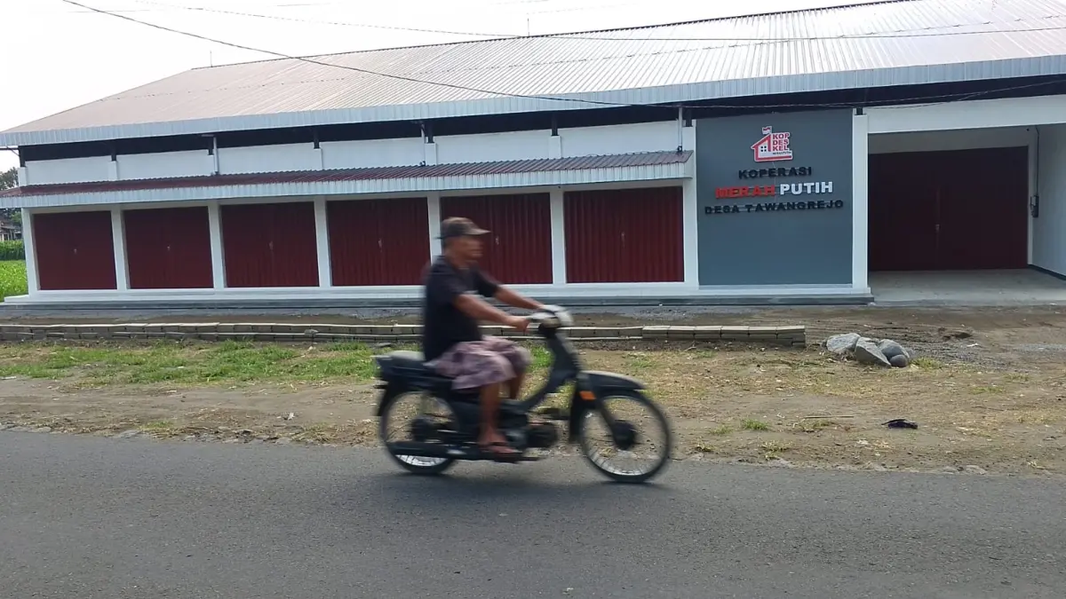 Seorang pengendara melintas di depan KDMP Tawangrejo Kecamatan Udanawu yang belum beroperasi. 