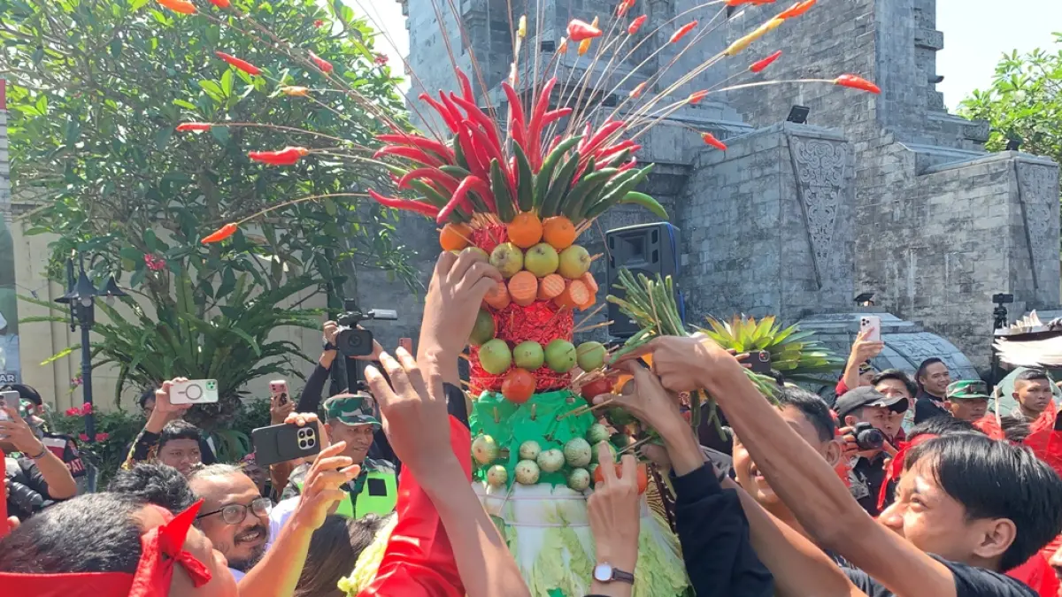 Masyarakat berebut gunungan hasil bumi di Makam Bung karno Kota Blitar, Senin (1/6/2026).