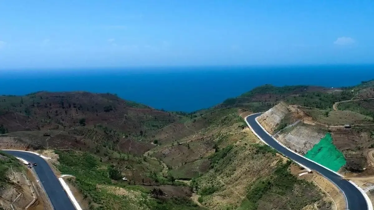 Ilustrasi suasana Jalur Lintas Selatan (JLS) yang menghubungkan Tulungagung dan Blitar. Ruas jalan ini menawarkan panorama laut biru tosca, perbukitan hijau, serta jalan beraspal mulus yang menjadi daya tarik baru bagi wisatawan dan pengguna jalan di pesisir selatan Jawa Timur.