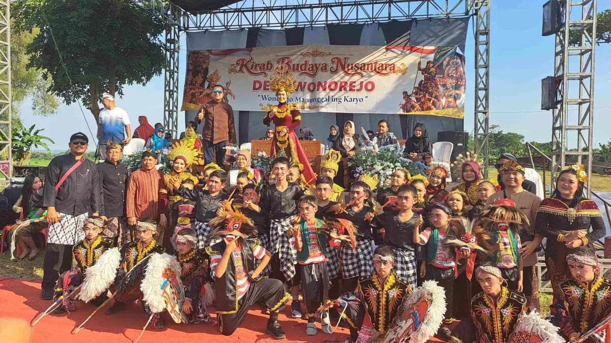 Rombongan SDN Wonorejo 01, melakukan foto bersama dengan Kepala Desa Wonorejo, Fendriana Anitasari ketika kirab budaya dalam rangka bersih desa, pada Sabtu (11/7).