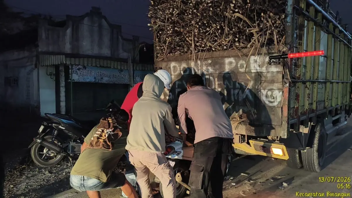 Petugas mengevakuasi sepeda motor Honda Scoopy usai menabrak truk pengangkut tebu yang parkir di Jalan Raya Rejoso, Binangun.