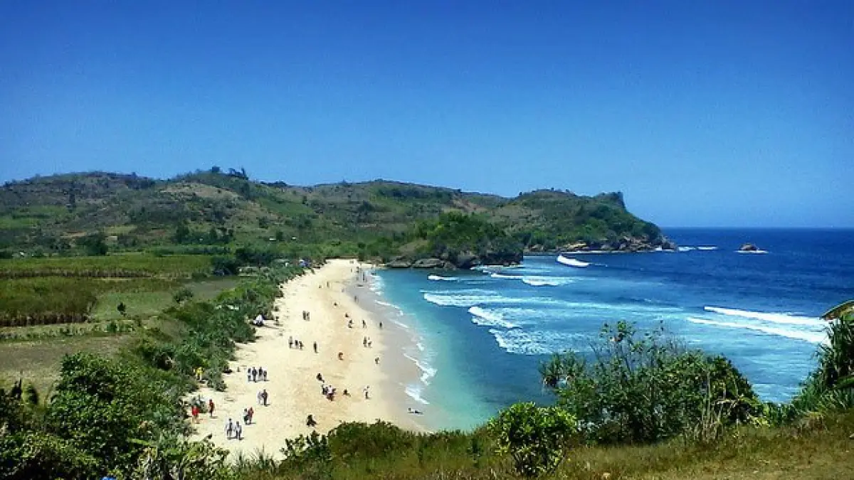 Pengunjung menikmati panorama Pantai Tambakrejo di Kabupaten Blitar yang tetap menjadi destinasi wisata favorit berkat fasilitas lengkap, kuliner seafood, dan harga tiket yang terjangkau pada 2026.
