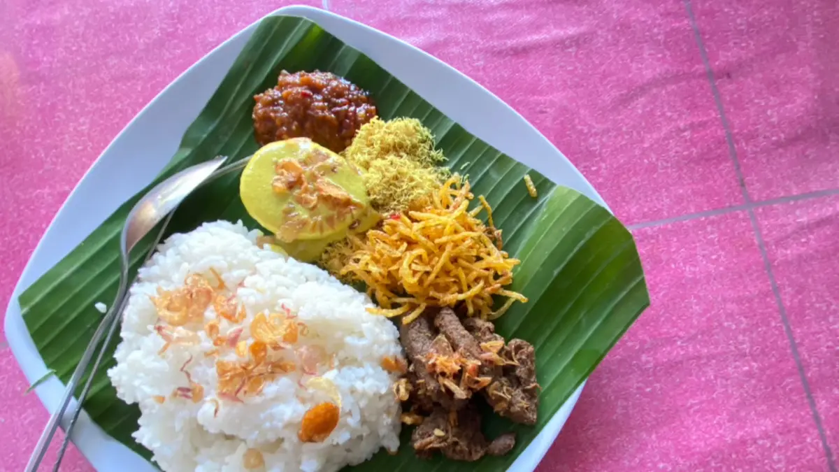 KAYA RASA: Sulaiha menunjukkan seporsi nasi krawu khas Madura berisi daging sapi, serundeng, kentang mustofa, telur rebus, dan sambal yang disajikan beralas daun pisang di kedainya, Jalan WR Supratman, Kota Blitar.