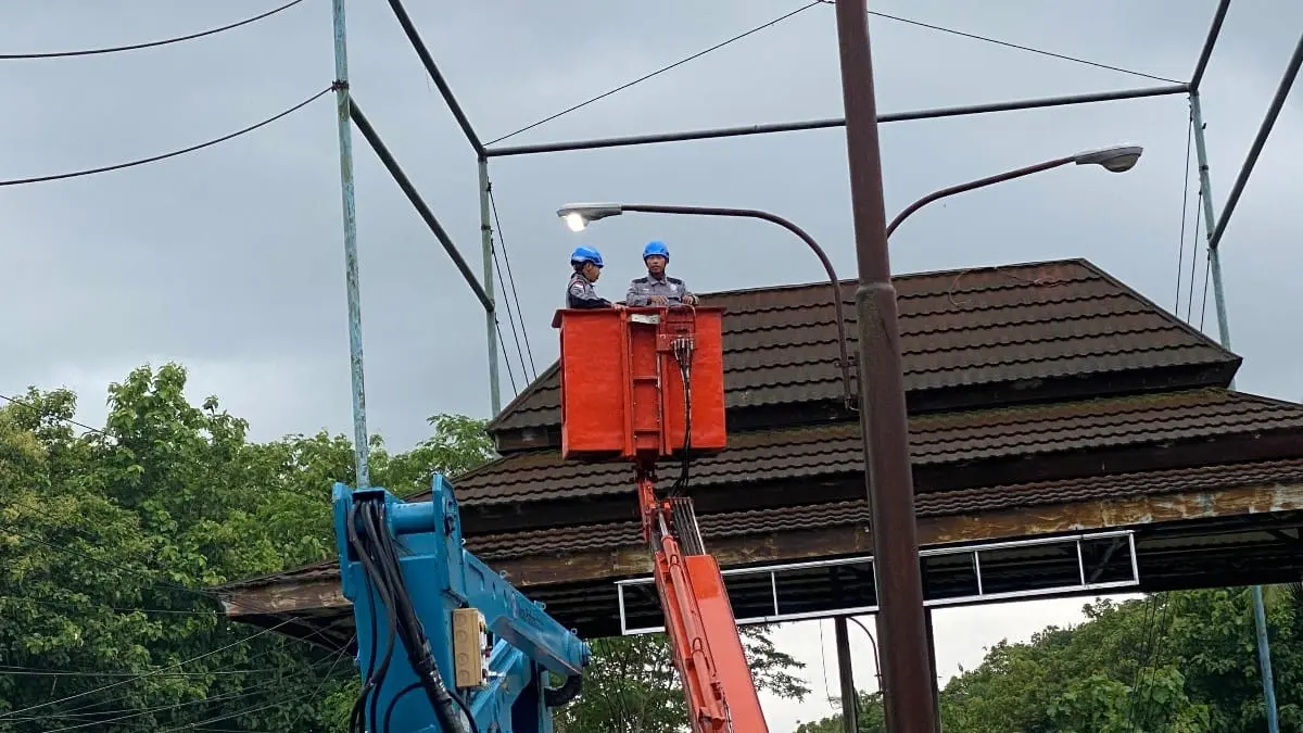 PERSONEL TERBATAS: Teknisi dishub memperbaiki lampu PJU di salah satu titik di Kabupaten Blitar.