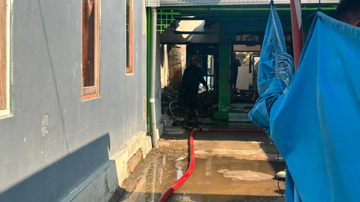 Petugas pemadam kebakaran memadamkan  api di rumah warga Kelurahan Klampok kemarin (26/7).