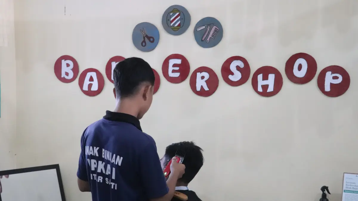 Seorang anak binaan LPKA Blitar berlatih memangkas rambut rekannya sebagai bagian dari pembinaan keterampilan. Selain menguasai barber, ia juga belajar menjadi barista sebagai bekal membuka usaha mandiri setelah bebas nanti.
