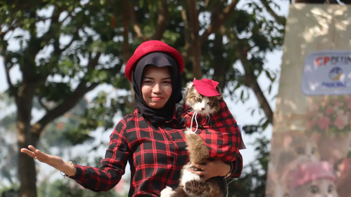 BIKIN GEMAS : Peserta fashion show menggendong kucing kesayangannya yang sudah dipakaikan busana, kemarin.