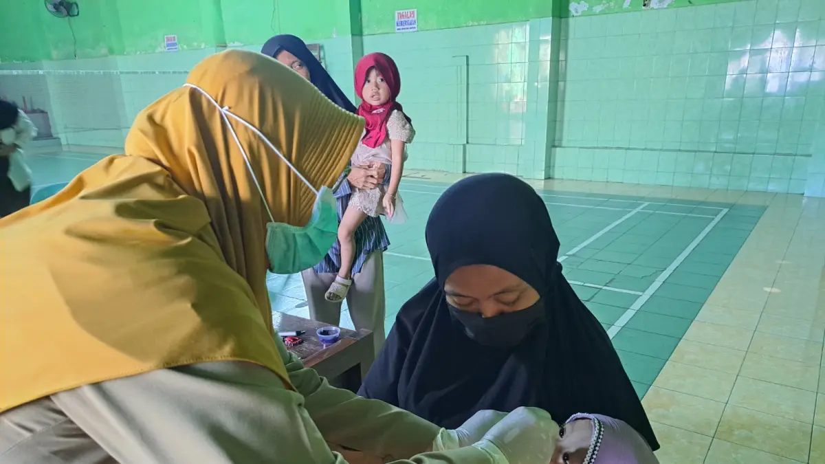 Tenaga kesehatan puskesmas memberikan vaksin kepada balita.