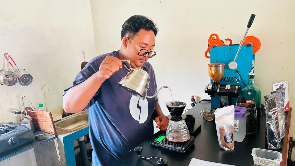COBA LANGSUNG: Bagos Tri Handono saat meracik kopi buatan sendiri di kafe sendiri.