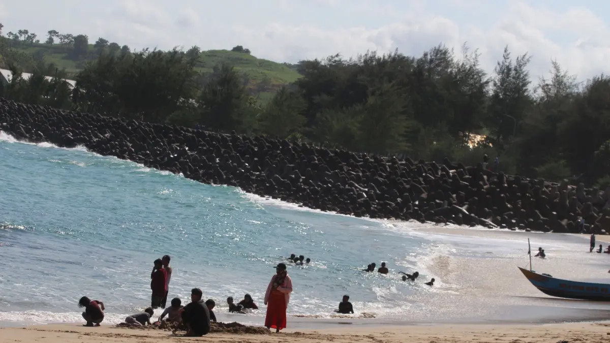 MOCHAMMAD SUBCHAN ABDULLAH/RADAR BLITAR
JUJUKAN WISATAWAN: Pengunjung menikmati deburan ombak Pantai Tambakrejo. Destinasi wisata alam menjadi unggulan di Kabupaten Blitar.
