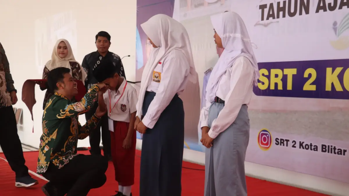FOTO-FOTO: FAJAR RAHMAD AW/RADAR BLITAR
PENDIDIKAN GRATIS: Wali Kota Syauqul Muhibbin mengalungkan kartu pengenal siswa sebagai tanda dimulainya MPLS di Sekolah Rakyat, Sabtu (15/8). 
