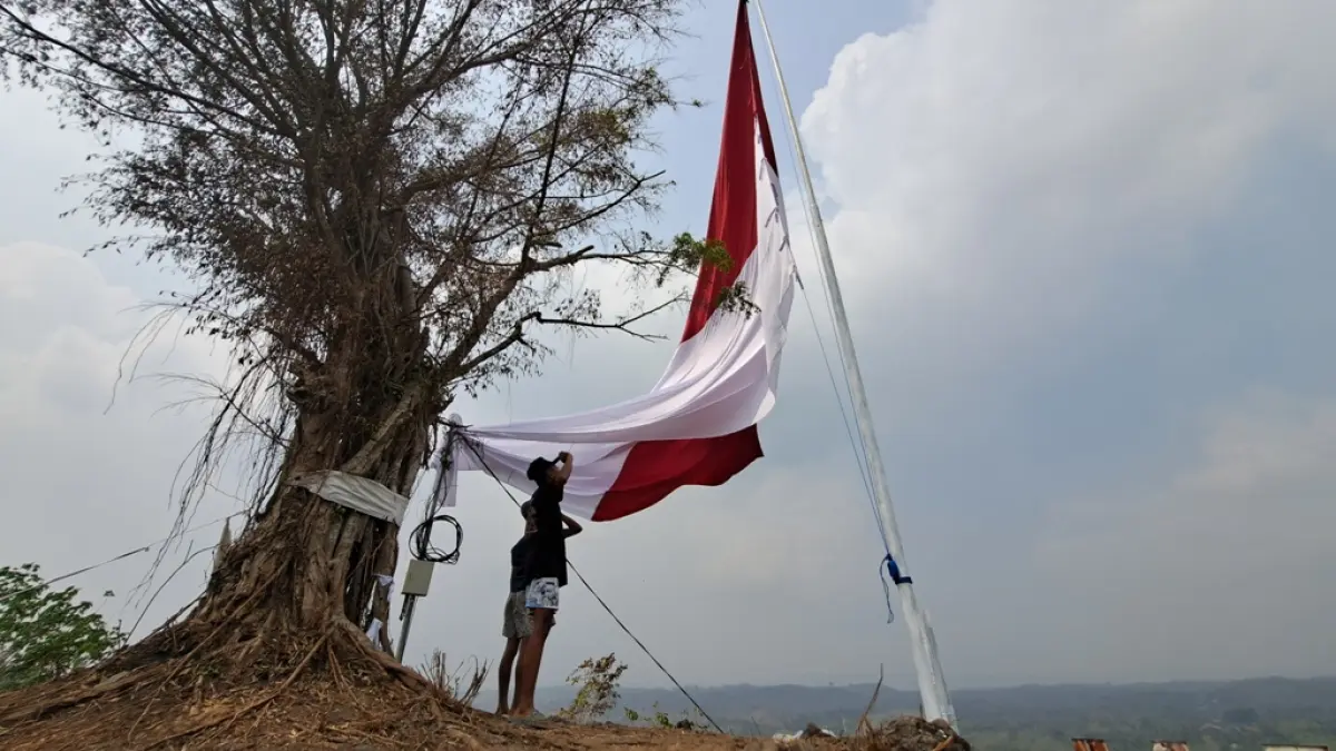 FAJAR RAHMAD AW/RADAR BLITAR
HORMAT GRAK: Seorang warga hormat kepada bendera merah putih raksasa di Bukit Plampangan di Desa Jugo, Kecamatan Kesamben, Senin (17/8). 