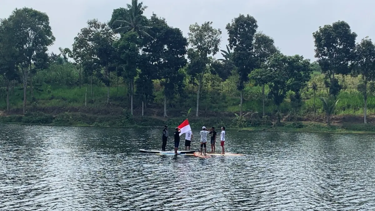 MOCH SUBCHAN ABDULLAH/RADAR BLITAR
HARUS SEIMBANG: Komunitas Stand Up Paddle Blitar hormat bendera di tengah Blumbang Gede, Desa Soso, Kecamatan Gandusari, Senin (17/8). 