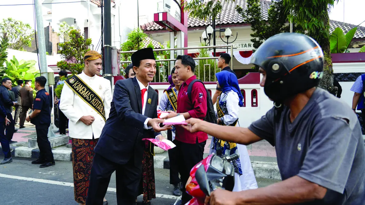 NASIONALISME: Wakil Ketua DPRD, Adi Santoso membagikan bendera merah putih kepada pengendara.
