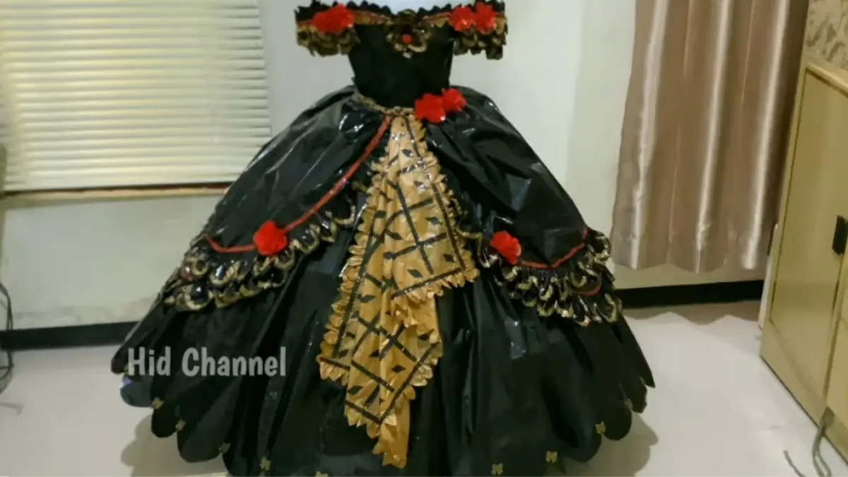 Gaun ratu malam dari plastik dibuat dengan perpaduan gold, hitam, merah, renda, dan bunga untuk menghasilkan busana dekoratif.